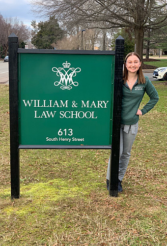 Corinne Cichowicz standing next to a sign for William and Mary Law School