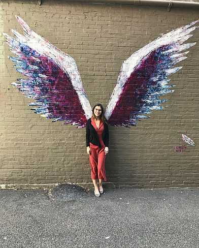 Alexandra Nigro standing in front of street art