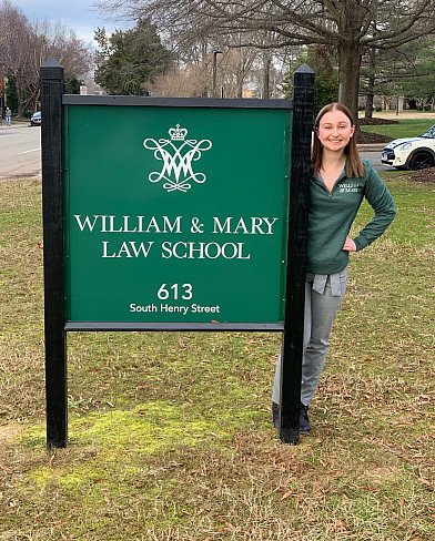 Corinne Cichowicz standing next to a sign for William and Mary Law School