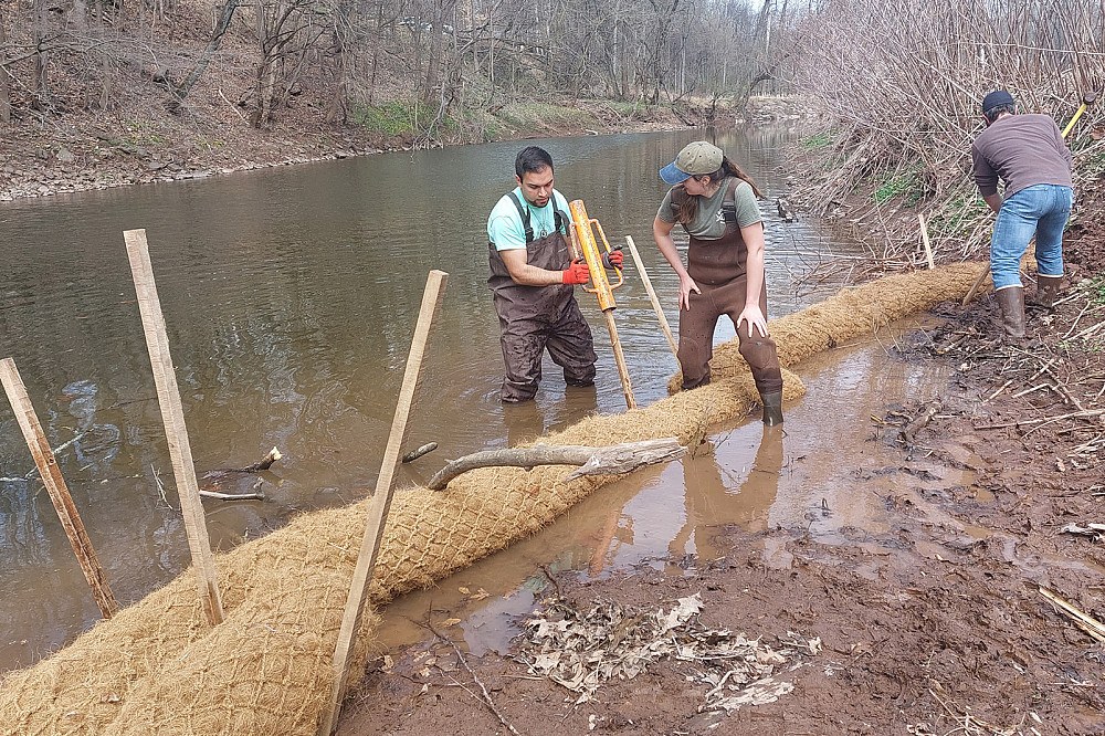Jeff Cocci '23 (left) and Lexi Fowler '23 (center) install core logs with Ryan Beltz as part of the Arcola Island project.