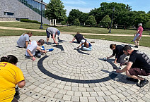 Photo of faculty and staff volunteers helping repaint the labyrinth located on campus.
