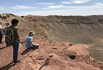 Ursinus students looking down over rim of a meteor crater during a Planetary Crater Consortium (PCC) field trip in August 2019.