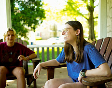 2 students talking on porch candid