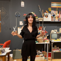 Lydia Ricci posing with scissors in her on-site studio.