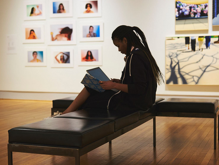 Student sitting looking at a paper in the Berman student exhibit.