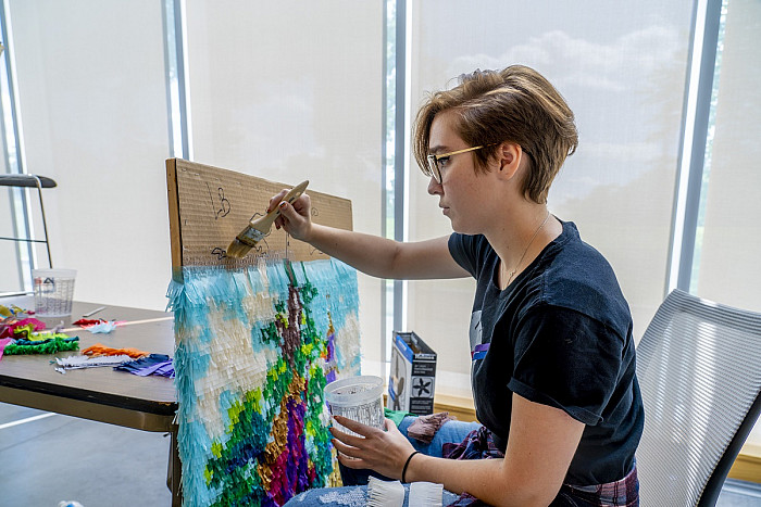 Dani Statuti '18 applies glue to a section of the mosaic.