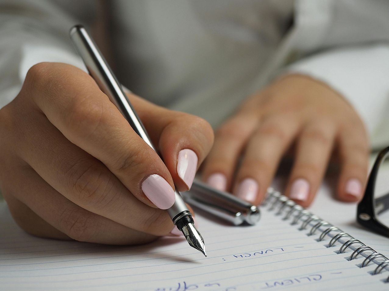 Person with pen writing on paper